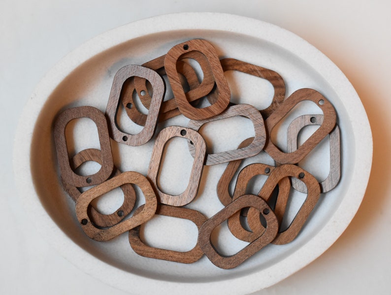 May include: A bowl of wooden oval-shaped rings with a light brown and dark brown color variation.