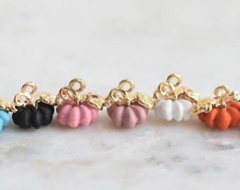 Può includere: Un set di otto ciondoli a forma di zucca in miniatura in vari colori, tra cui nero, bianco, rosa, rosa chiaro, arancione e blu. Ogni ciondolo presenta un anello dorato per essere attaccato a gioielli o altri oggetti artigianali.