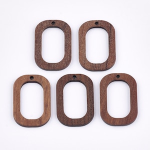 May include: Five wooden oval-shaped pendants with a hole at the top. The pendants are a dark brown color and have a smooth, polished finish.
