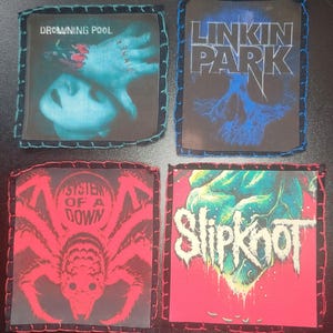 May include: Four square fabric patches featuring band logos and artwork. Top left: Drowning Pool Sinner with a hand over a face. Top right: Linkin Park with a blue skull graphic. Bottom left: System of a Down with a red spider. Bottom right: Slipknot logo.