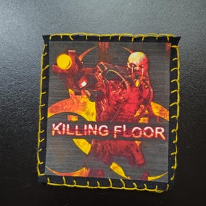 May include: Square patch featuring a red and yellow illustration of a creature with a weapon, with the text "KILLING FLOOR" in white. The patch has a black border with yellow stitching.