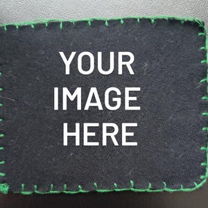 K&ouml;nnte beinhalten: Ein schwarzer rechteckiger Aufn&auml;her mit dem wei&szlig;en Text "YOUR IMAGE HERE". Der Aufn&auml;her hat einen gr&uuml;n gen&auml;hten Rand. Das Bild ist eine Nahaufnahme.