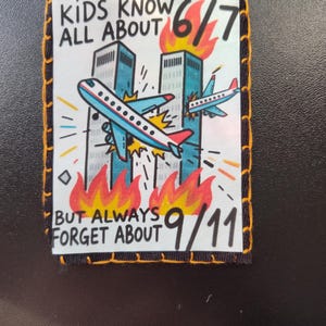 May include: Embroidered patch with a cartoon illustration of two airplanes crashing into the Twin Towers, with flames and the text "KIDS KNOW ALL ABOUT 6/7 BUT ALWAYS FORGET ABOUT 9/11". The patch has a yellow stitched border.