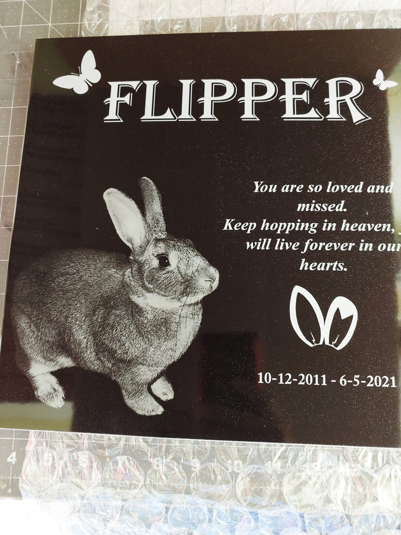 Pu&ograve; includere: Placca commemorativa in granito nero con un'immagine incisa in bianco di un coniglio e il testo "FLIPPER"  "You are so loved and missed. Keep hopping in heaven, will live forever in our hearts."  "10-12-2011 - 6-5-2021"
