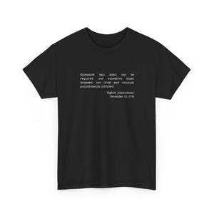 May include: A black short-sleeved t-shirt featuring white typewriter-style text that reads: Excessive bail shall not be required, nor excessive fines imposed, nor cruel and unusual punishments inflicted. Eighth Amendment December 15, 1791.