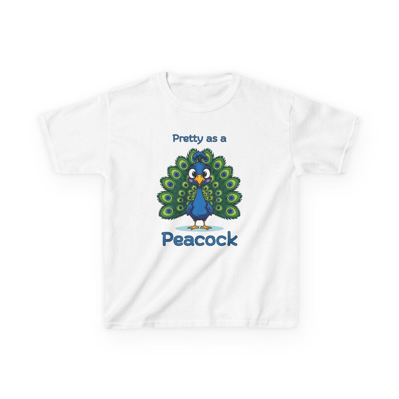 Op de afbeelding: Wit kinder-T-shirt met een cartoon pauw met een blauw lichaam, groene en blauwe staartveren en de tekst "Pretty as a Peacock" in het blauw. Het T-shirt is voor kinderen.