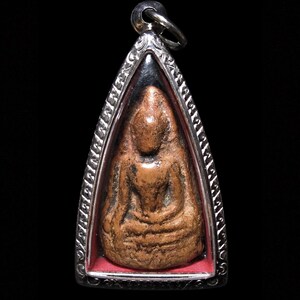 May include: A bronze-colored Buddha pendant, encased in a silver-toned, triangular frame. The Buddha figure is seated in a meditative pose, with intricate details visible. The pendant has a small loop at the top for a chain. The background is black.