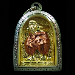 Può includere: Ciondolo dorato raffigurante una figura seduta con una veste color rame. Il ciondolo ha una cornice color argento con dettagli ornati e un anello per appenderlo. Lo sfondo è dorato.