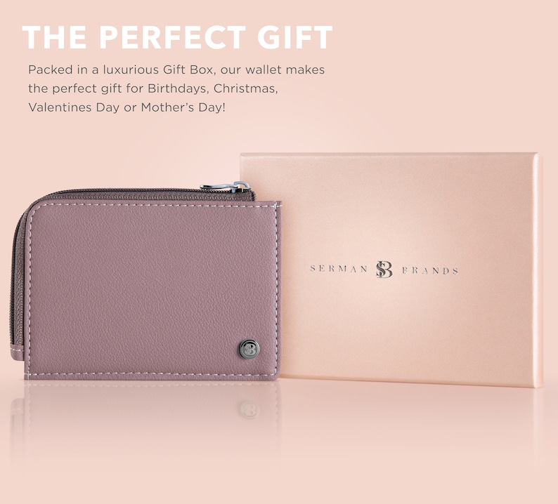 May include: A mauve leather wallet with a zipper closure and a silver logo. The wallet is in a gift box with the text "SERMAN BRANDS" on the top.