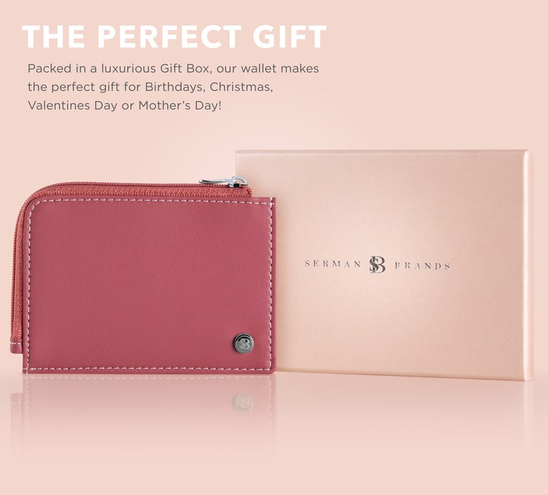 May include: A dusty rose-colored wallet with a zipper closure and white stitching, next to a matching gift box. The wallet has a small metal emblem. The text "SERMAN BRANDS" is on the gift box.