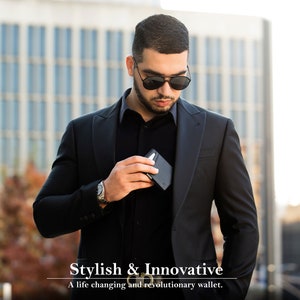 May include: A man wearing a black suit jacket and sunglasses is holding a black wallet in his hand. The text "Stylish & Innovative" and "A life changing and revolutionary wallet." is below the man.