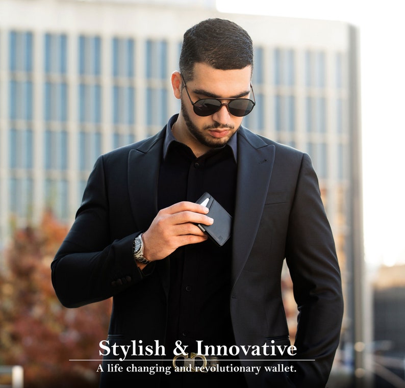 May include: A man wearing a black suit jacket and sunglasses is holding a black wallet in his hand. The text "Stylish & Innovative" and "A life changing and revolutionary wallet." is below the man.