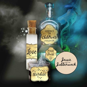 May include: Three glass bottles with gold labels and black text. The labels read "Love", "Pixie Dust", and "Essence of Children's Laughter". A fourth bottle with a gold label that reads "Stardust" is in the foreground. A round, beige label with black text reads "Jessie and the Jabberwock".