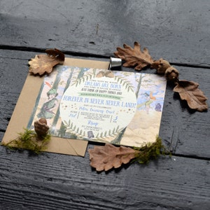 May include: A whimsical invitation for a first birthday party with a Peter Pan theme. The invitation features a watercolor illustration of Peter Pan and Tinkerbell in Neverland, with the text "Come with me where dreams are born and time is never planned. Just think of happy things and your heart will fly on wings. Forever in Never Never Land!" and "Peter turning One!" The invitation is decorated with stars, leaves, and a brown envelope.