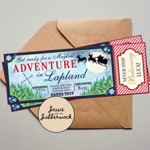 Puede incluir: Un billete azul y rojo con el texto "Get ready for a Magical Adventure in Lapland" y "DECEMBER 17TH" y "CROSS THE ARTIC CIRCLE ENCHANTED FOREST SNOWFLAKE AVENUE BOUND TRIP" y "DEPARTURE 8AM". El billete tiene una imagen de Pap&aacute; Noel volando en un trineo con renos sobre un bosque nevado.