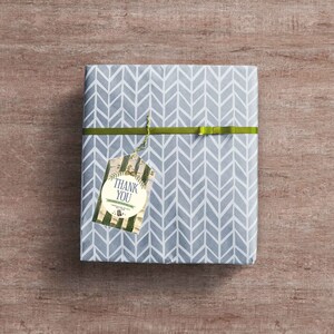 May include: A gray gift box with a chevron pattern wrapped with a green ribbon and a gift tag that says "Thank You".