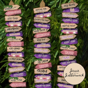 May include: A set of 14 wooden signs with purple and pink glitter accents, each with a different message related to a festival or party. The signs are arranged in two columns, with the text facing the viewer. The signs include messages such as "Disco Deck", "Good Tunes", "Teepees", "Wristbands", "Tattoos", "Toilets This Way", "Bubbles & Beats", "Fun & Games", "Bonfire", "Flower Crowns", "Glitter", "Silent Disco", "Merchandise", "Secret Stage", "Glamping", "Festival Fuel", "Main Stage", "Tonight's the Night", "When Sparks Fly", "Never Grow Up", "Love Story", "Mosh Pit", "Cinema", "First Aid", "Car Park", "Ice Cream", "Rides", "Trouble", "Fairytale", "Welcome", "Follow the Beats", "Face Paints", "DJ", "Let's Get Lost in Wonderland", "Lavender Haze", "Meeting Point", "Photobooth", "Zen Den", "Craft Tent", "Faraway Forest", "Rave", "Bar", "Chill Out Zone", "Festivities", "Back", "Camp", "VIP Lounge".