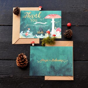 May include: A thank you card with a whimsical illustration of a mushroom and fairies. The card has a green background with gold stars and the text "Thank You" in gold lettering. The card also includes the text "So Fairy Much" and "You made my birthday so magical! Never stop believing!" in smaller gold lettering. The card is signed "Elodie" and includes the text "Lots of Love Fairy Dust".