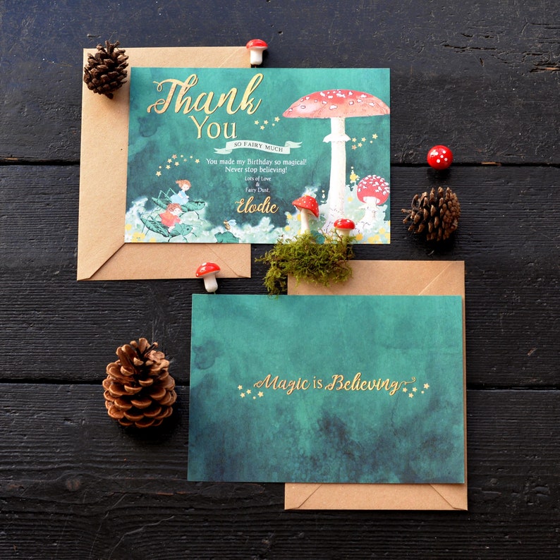 May include: A thank you card with a whimsical illustration of a mushroom and fairies. The card has a green background with gold stars and the text "Thank You" in gold lettering. The card also includes the text "So Fairy Much" and "You made my birthday so magical! Never stop believing!" in smaller gold lettering. The card is signed "Elodie" and includes the text "Lots of Love Fairy Dust".