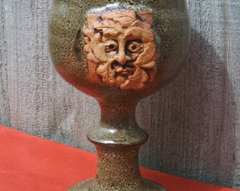 Hand thrown and decorated stoneware wine goblet with raised Green Man motif 14cmx8cm