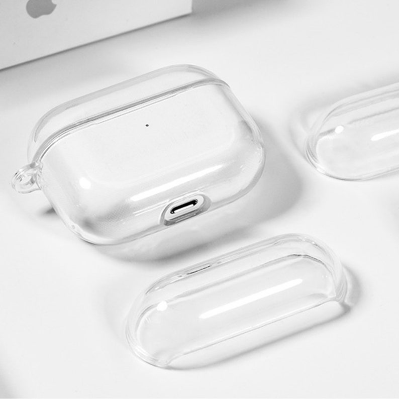 May include: Three clear plastic cases for wireless earbuds. The largest case has a charging port on the bottom.
