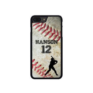 May include: A black iPhone case with a baseball graphic. The baseball is white with red stitching and a brown background. The text "HANSON 12" is printed on the case. A silhouette of a baseball player is swinging a bat.