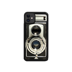 May include: Black phone case with a vintage camera design. The camera has two lenses and a silver finish.