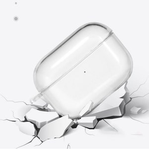 May include: A clear plastic case for wireless earbuds, shown falling onto a cracked surface. The case is designed to protect the earbuds from damage.