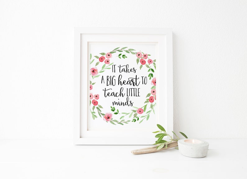 May include: White framed print with a floral wreath and the text "It takes a big heart to teach little minds".