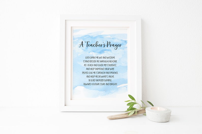 May include: A framed print with a blue watercolor background and the text "A Teacher's Prayer". The poem reads: "God grant me wit and wisdom stand beside me through each day as I teach and guide my students and help them find their way. Please give me strength and patience and help me do what's right to lead them by example toward a future sure and bright!"