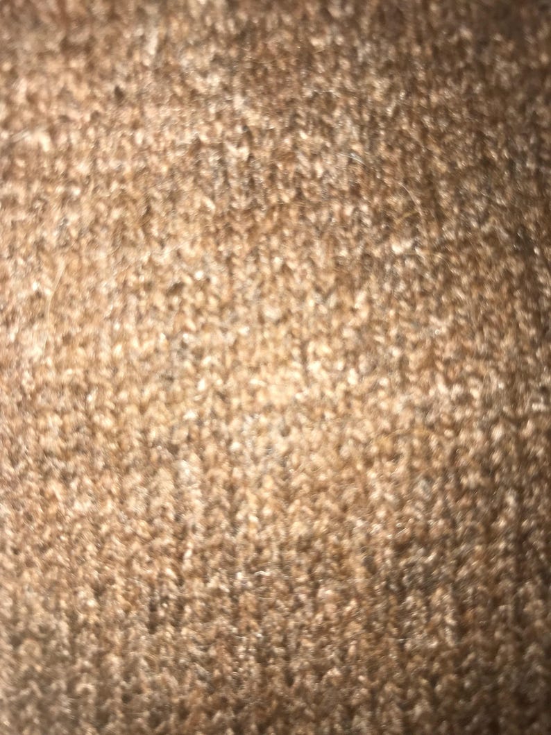 May include: Close-up of a brown carpet with a soft, fuzzy texture.