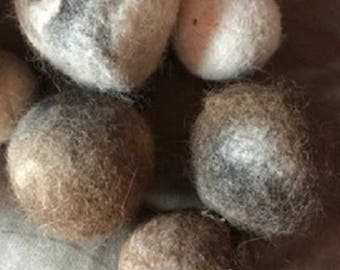 May include: A close-up of six felted wool dryer balls in various shades of brown, gray, and white. The balls are soft and fluffy, and they are perfect for adding a natural touch to your laundry routine.