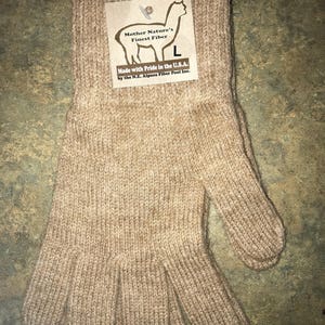 May include: A pair of brown alpaca wool gloves. The gloves are knitted and have a ribbed texture. The gloves are made in the USA by the N.E. Alpaca Fiber Pool Inc.