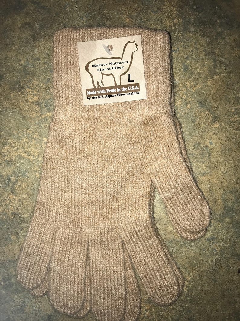 May include: A pair of brown alpaca wool gloves. The gloves are knitted and have a ribbed texture. The gloves are made in the USA by the N.E. Alpaca Fiber Pool Inc.