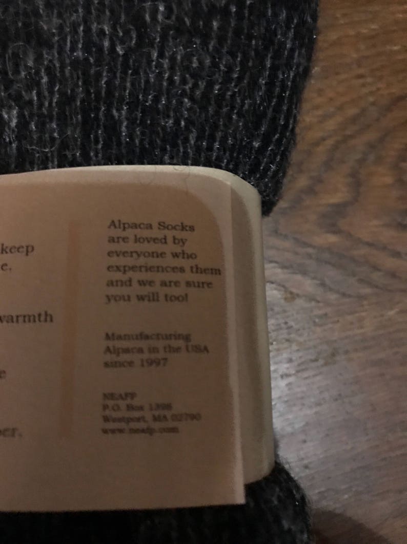 May include: A white label with black text that reads "Alpaca Socks are loved by everyone who experiences them and we are sure you will too!"  Manufacturing Alpaca in the USA since 1997. NEAFP P.O. Box 1306 Westport, MA 02790 www.neafp.com