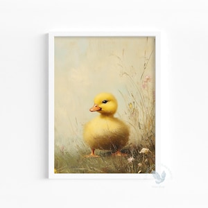 May include: A framed print featuring a fluffy yellow duckling standing in a field of tall grass and wildflowers. The duckling has an orange beak and is set against a soft, pastel-colored background. The artwork has a vintage, painterly style.