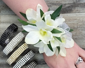 Ramillete de orquídeas blancas crema con pedrería, detalles de cinta (en caja). Artículos a juego disponibles.