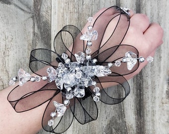 Corsage con cuentas de cristal Swarovski, pulsera de encaje y cinta, en caja. Artículos a juego disponibles.