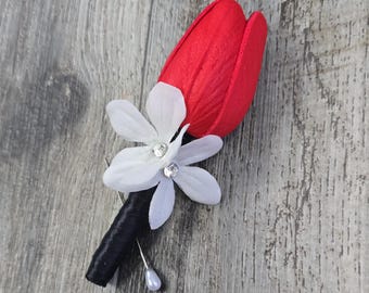 Boutonniere con tulipanes rojos Real Touch y flores de estefanotis blancas con centros de diamantes, presentado en caja. Incluye ramilletes a juego.