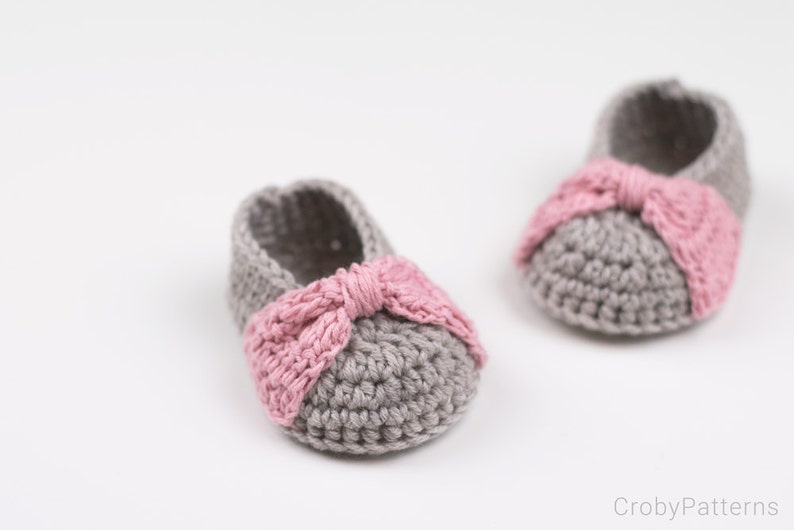 Puede incluir: Un par de botitas de beb&eacute; de crochet gris con lazos rosas. Las botitas est&aacute;n hechas con un hilo suave y tienen un ajuste c&oacute;modo.