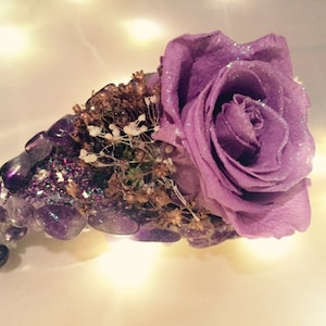 May include: A single purple rose with glitter is preserved in a crystal-shaped arrangement of amethyst stones and gold accents.