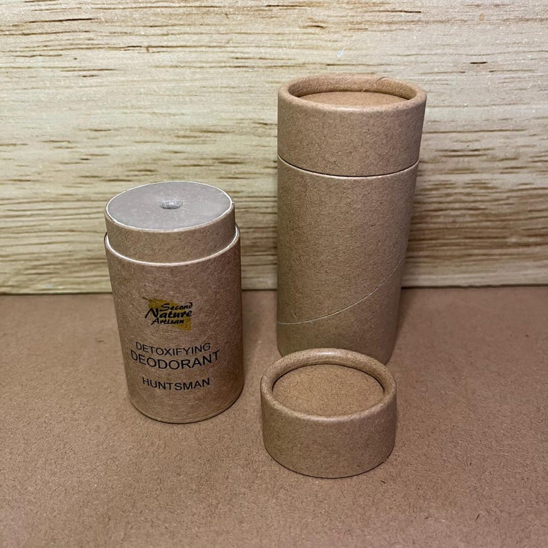 May include: A brown cardboard tube with a white label that says "Second Nature Artisan Detoxifying Deodorant Huntsman".