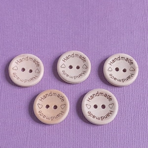 May include: Four wooden buttons with the word "Handmade" and a heart symbol on each button.