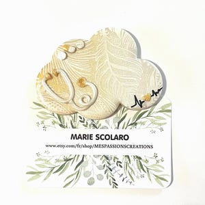 Insignia para enfermera/cuidador, fondo degradado en dorado y nácar, plumas serigrafiadas, estetoscopio y tema de pastillas.