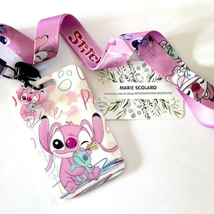 May include: A pink lanyard and card holder set featuring a cartoon character. The lanyard has the word "Stitch" in red. The card holder has a cartoon character holding a doll. A business card is also present.