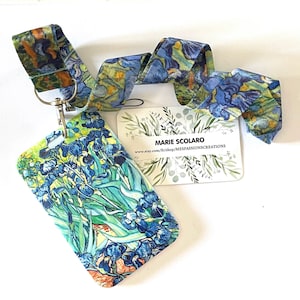 Puede incluir: Un cordón con un diseño floral inspirado en la pintura "Lirios" de Van Gogh. El cordón tiene una correa a juego y un cierre de metal. También hay una tarjeta de visita con el texto "MARIE SCOLARO".