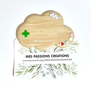 Puede incluir: Un pin de madera en forma de nube con pastillas verdes y blancas, una pastilla roja y blanca y una pastilla azul y blanca. El pin está en una tarjeta blanca con hojas verdes y el texto "MES PASSIONS CREATIONS www.etsy.com/fr/shop/MESPASSIONSCREATIONS".