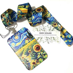 Puede incluir: Un juego de cordón y tarjetero con un estampado de "La noche estrellada" de Van Gogh y girasoles. El cordón es azul, amarillo y verde. El tarjetero tiene un cierre plateado y una cuerda negra. También se incluye una tarjeta de visita.