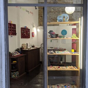 May include: A shop window display in Florence, Italy, featuring colourful jewellery and accessories. The shop is called "My store/lab's in Firenze, Italy".