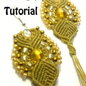 May include: A pair of handmade macrame earrings in olive green, adorned with gold and clear beads, and a large amber-colored bead in the center. The earrings have a leaf-like design and are suspended from silver-colored hooks. The word "Tutorial" is written in black.